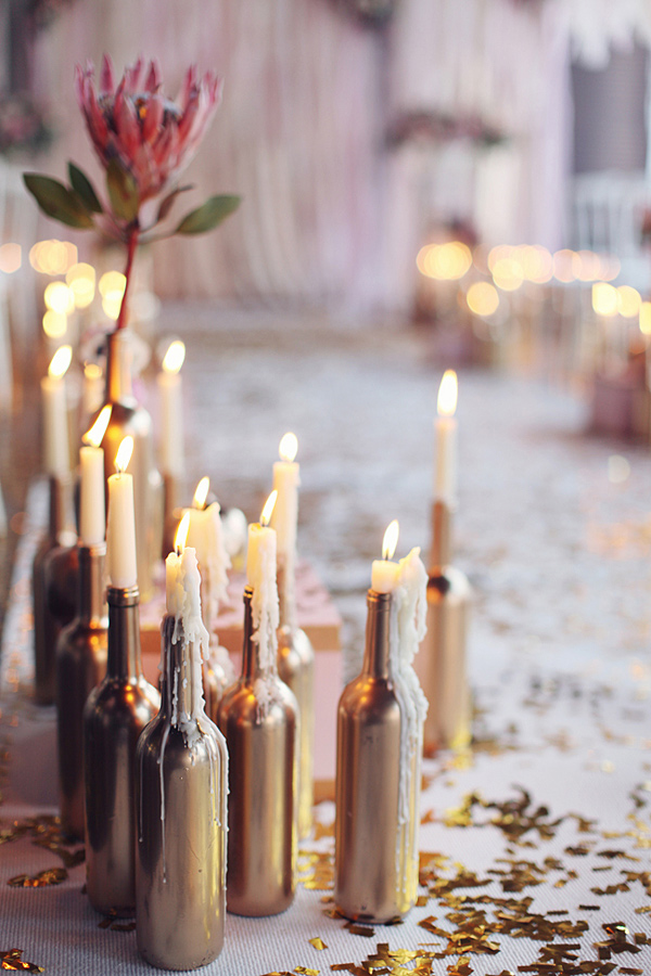 DIY candlestick holders with old wine bottles and gold spray paint. // 15 Stunning Ways to Decorate with Candles // http://mysweetengagement.com