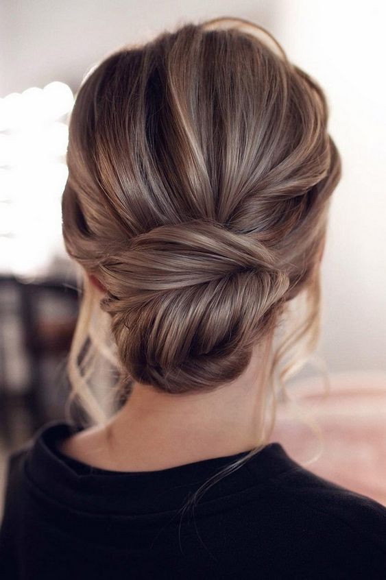 Elegant and timeless low hair bun idea with loose face-framing strands.