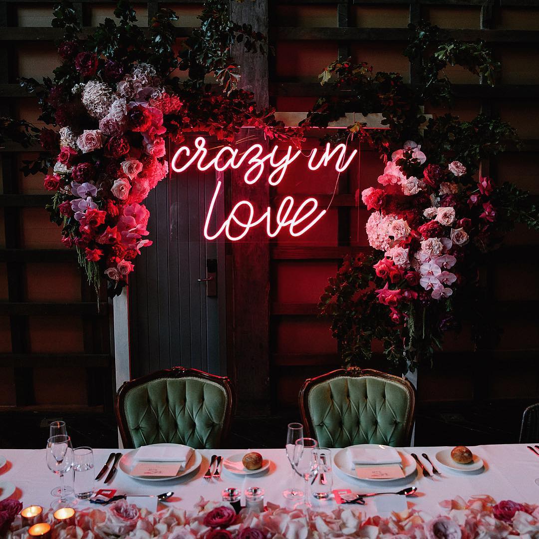This pink neon sign got us "Crazy in Love". How gorgeous is the bright neon sign paired with the romantic floral arrangements? // Fun and bright neon wedding sign decor ideas // mysweetengagement.com