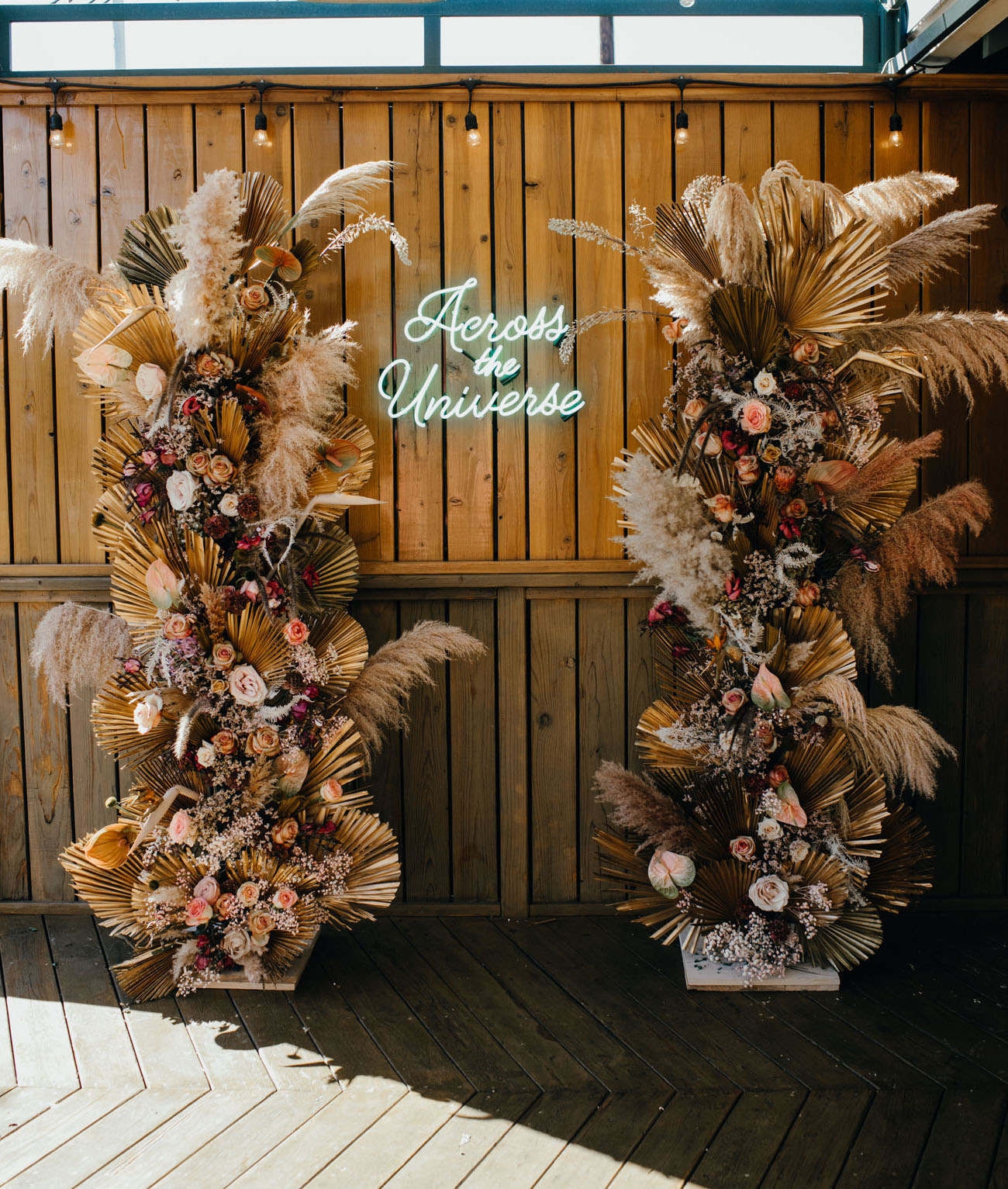 "Across the universe" gorgeous wedding ceremony backdrop sign, the perfect modern accent to a pampas grass altar. // Fun and bright neon wedding sign decor ideas // mysweetengagement.com