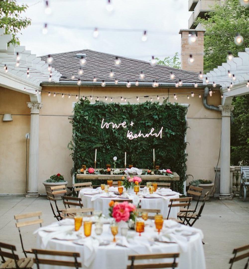 Bright and relaxed outdoor wedding reception decor with a gorgeous neon lettering sign on a greenery backdrop. // Fun and bright neon wedding sign decor ideas // mysweetengagement.com