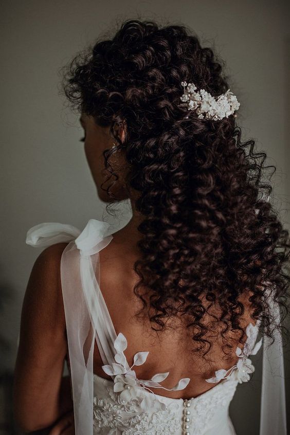 Natural curl half up half down hairdo idea with small floral embellishment. // Gorgeous half up half down bridal hairstyle ideas to impress on your wedding day. // mysweetengagement.com