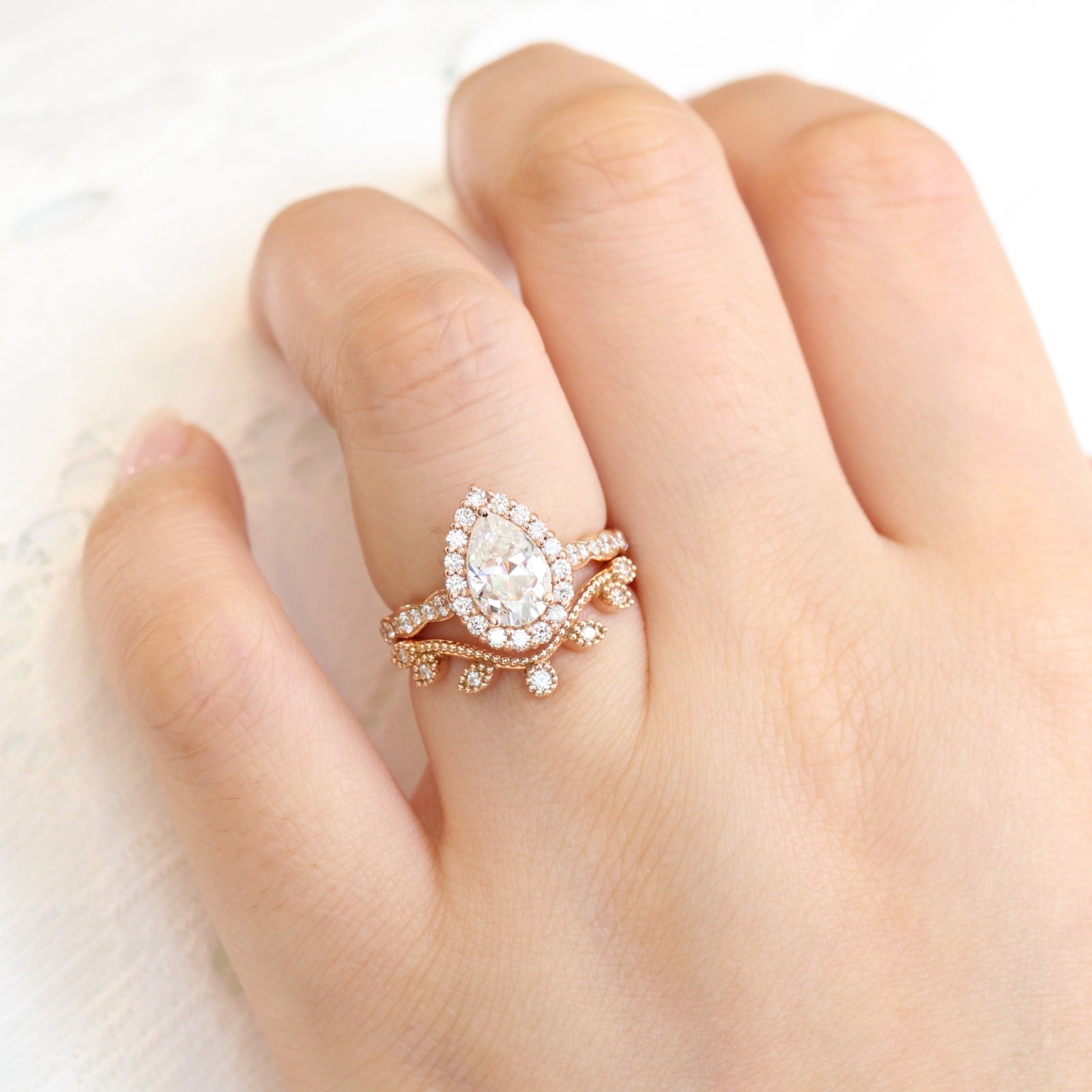 Pear shaped (teardrop) engagement ring ideas: Rose gold halo diamond on a scalloped band setting, pairing beautifully with a curved leaf diamond wedding band. // mysweetengagement.com