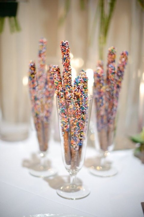 Confetti covered pretzel sticks served on tall glasses. See More Trendy and Creative Ideas to Serve Pretzel on Your Wedding. | My Sweet Engagement