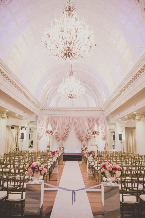Pink flowers and draping backdrops and gold accents will set the perfect tone for a classic and romantic indoor wedding ceremony. // ❤ Check Out These Gorgeous 20 Indoor Wedding Ceremony Ideas. // http://mysweetengagement.com/indoor-wedding-ceremony-ideas