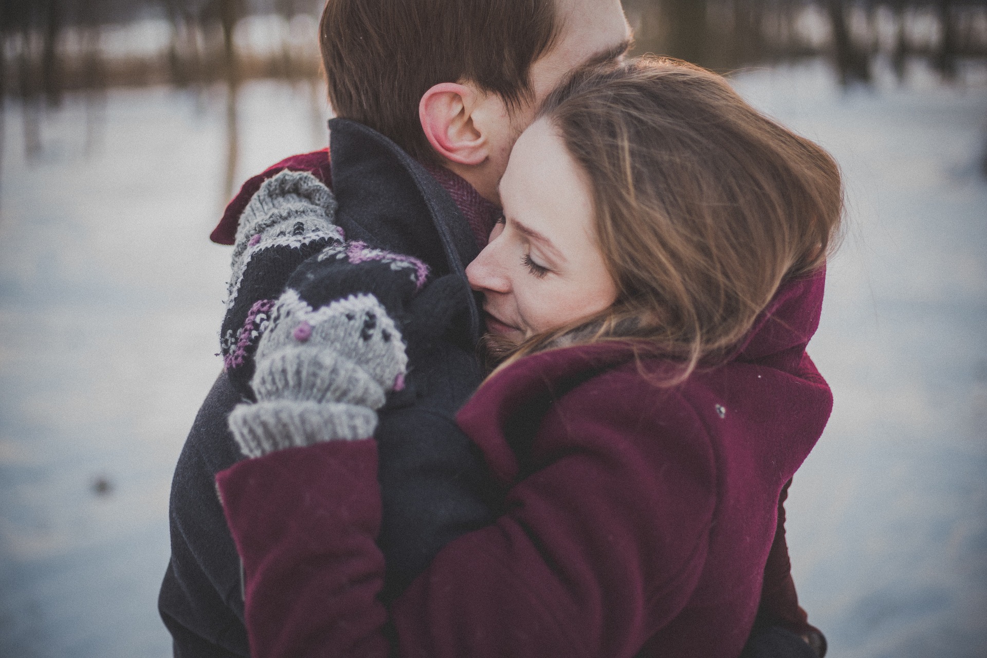 couple on engagement session with a passionate hug on the snow