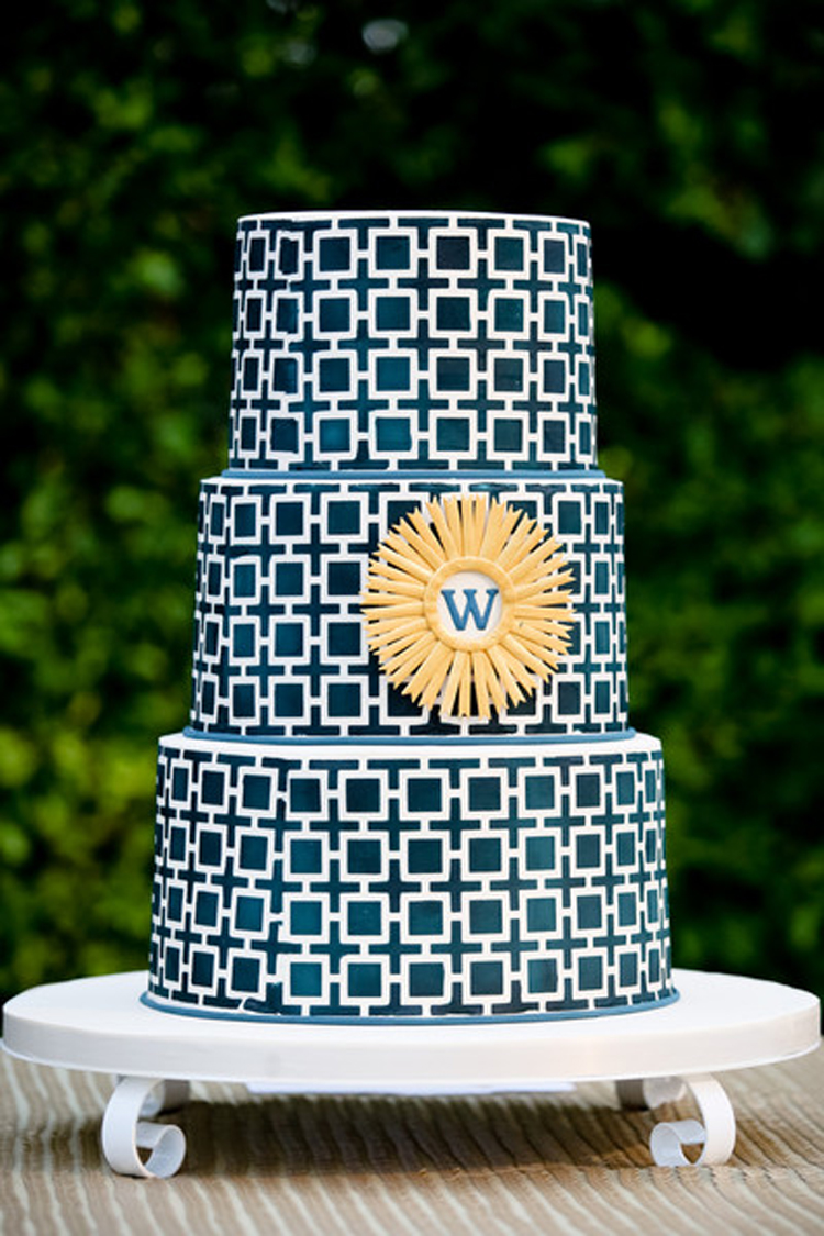 Geometric blue and white wedding cake with yellow new last name initial | See more: https://mysweetengagement.com/15-extraordinary-wedding-cakes-for-all-wedding-styles