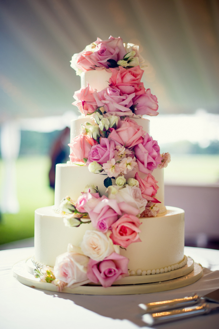 White wedding cake with piink shades of flowers in cascade style | See more: https://mysweetengagement.com/15-extraordinary-wedding-cakes-for-all-wedding-styles