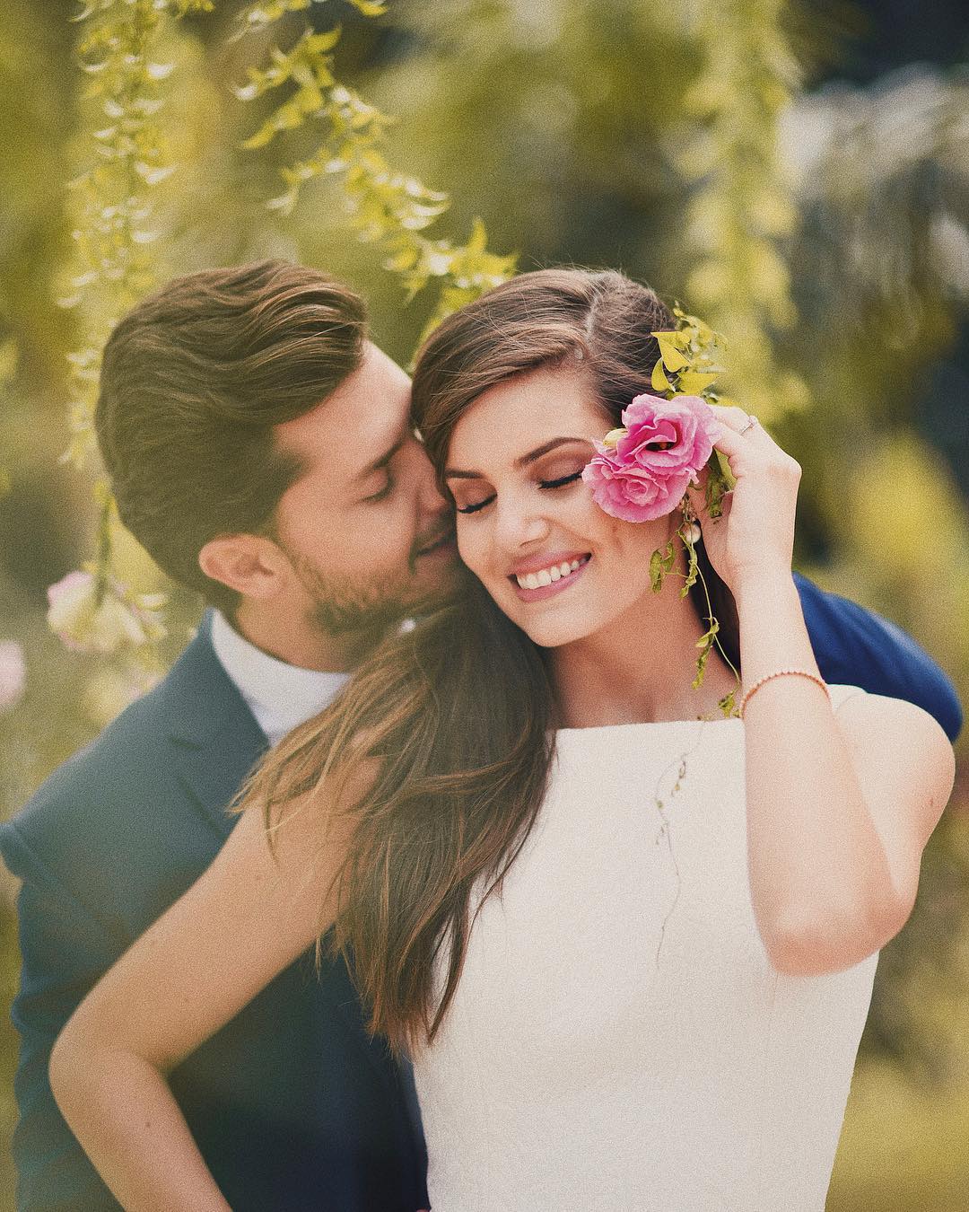 Romantic couple pose idea for a portrait. The groom is rocking an elegant navy blue suit and the bride a stunning mid length white dress with embroidered flowers. // ❤️This civil Wedding is absolutely delightful (Camila Queiroz and Kleber Toledo I Do's) // https://mysweetengagement.com/