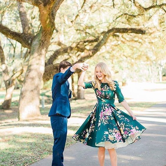 Adorable pose idea for couples. Love her floral Green Romantic Dress. // Don't know what to wear for your engagement pictures? Check out these 10 Formal Engagement Photo Outfit Ideas. // https://mysweetengagement.com
