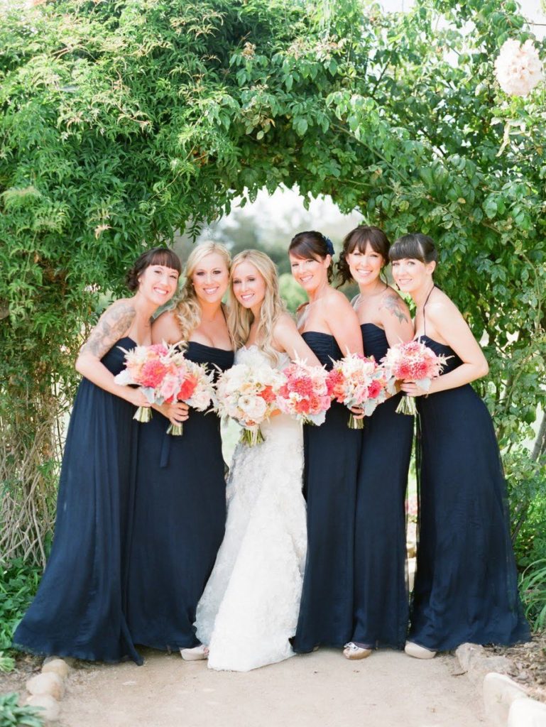 Strapless navy blue bridesmaid dresses and living coral wedding bouquets. 