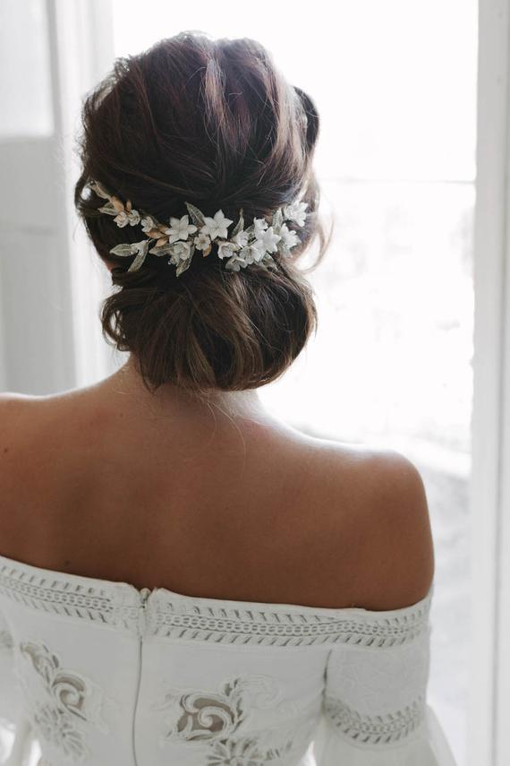Elegant chignon embellished with floral jewelry. 