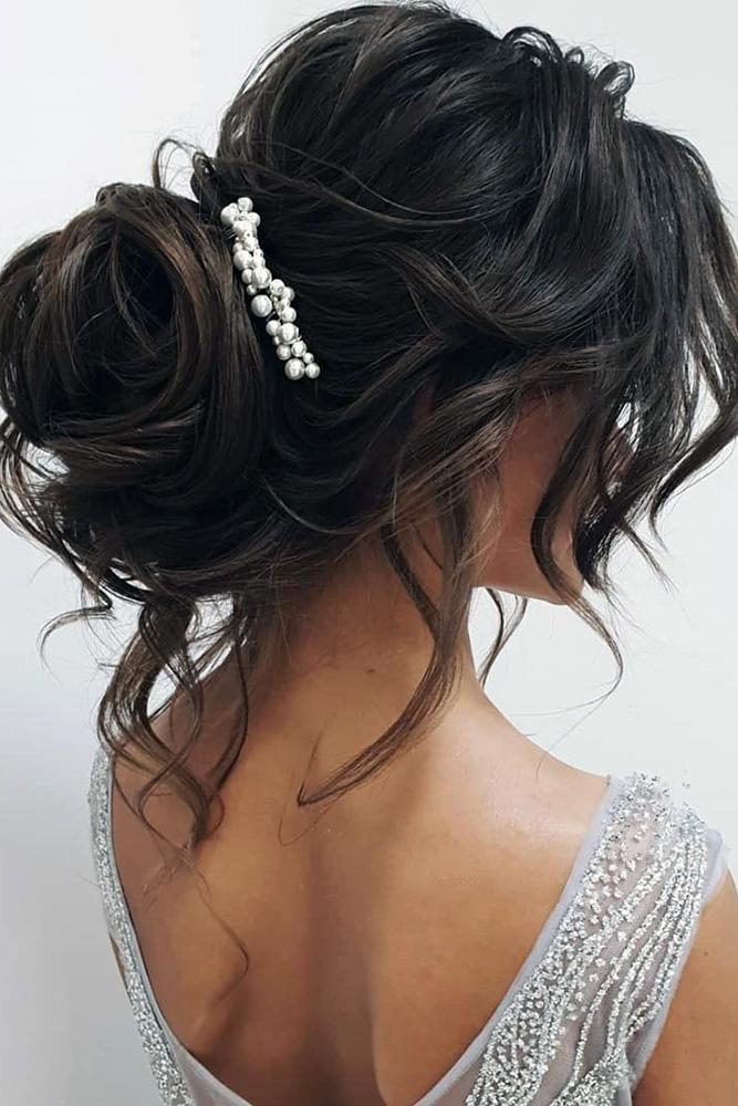 Pouffy messy hair bun with a voluminous bun and loose strands. 