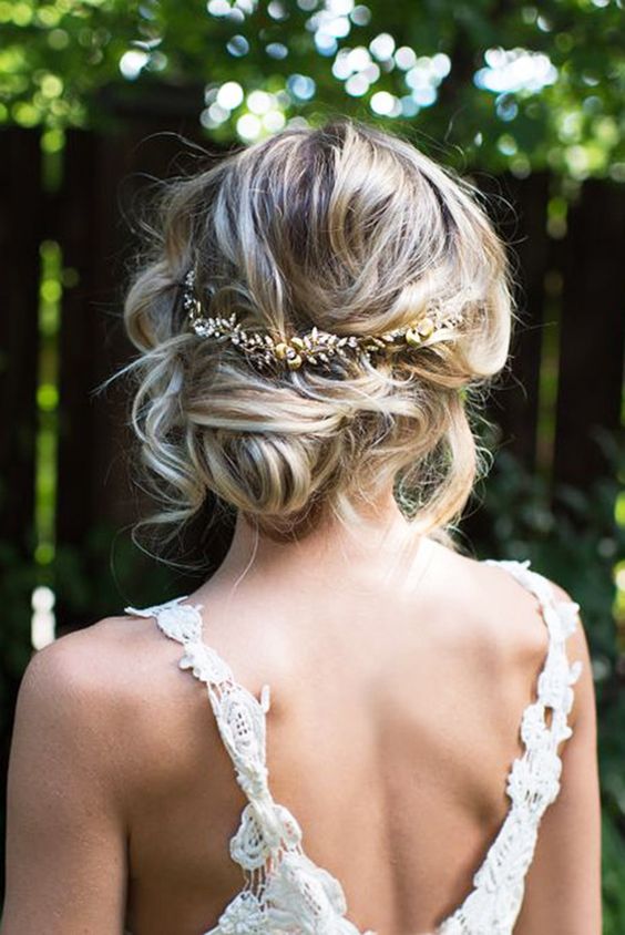  Messy updo with loose strands, twisted low bun and gold hairpiece.