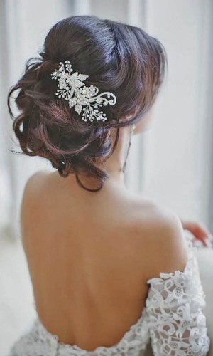 Classic bride wedding hair inspiration with pouf crown, big curls and a statement hairpiece. 