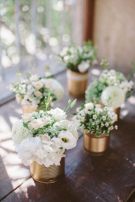 DIY table centerpiece arrangement with gold spray paint and metal cans. Beautiful floral arrangements with white flowers and greeneries. // Check out 50+ original wedding decoration ideas. // mysweetengagement.com