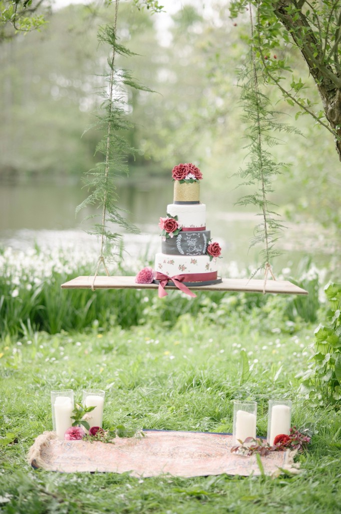 Garden wedding cake inspiration. Gold and white cake with chalkboard and burgundy details on a hanging swing display. // Jaw-dropping suspended cake display ideas for your wedding day. // mysweetengagement.com