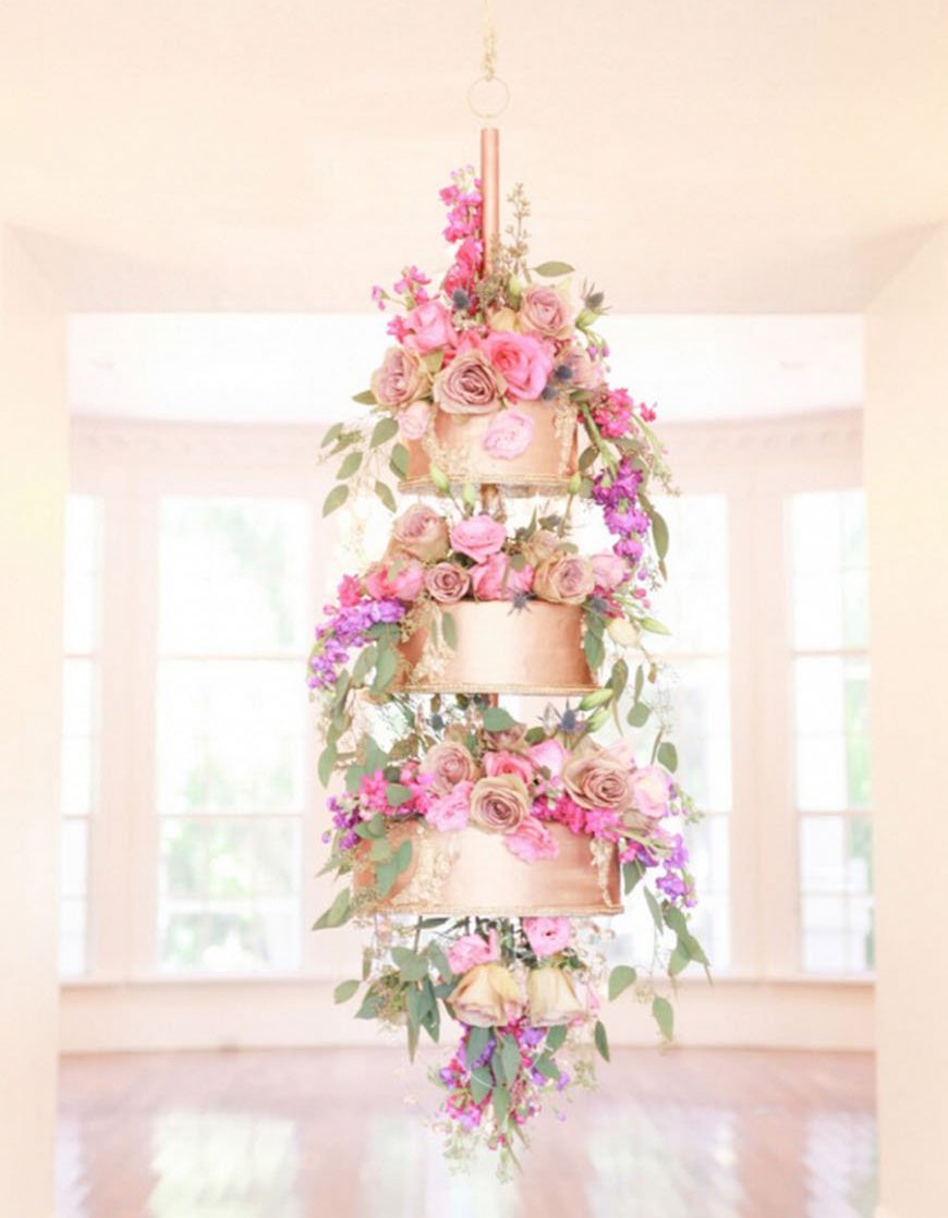 Rose Gold glam tiered wedding cake, hanging from the ceiling like a chandelier style and lots of pink flowers. // Jaw-dropping suspended cake display ideas for your wedding day. // mysweetengagement.com
