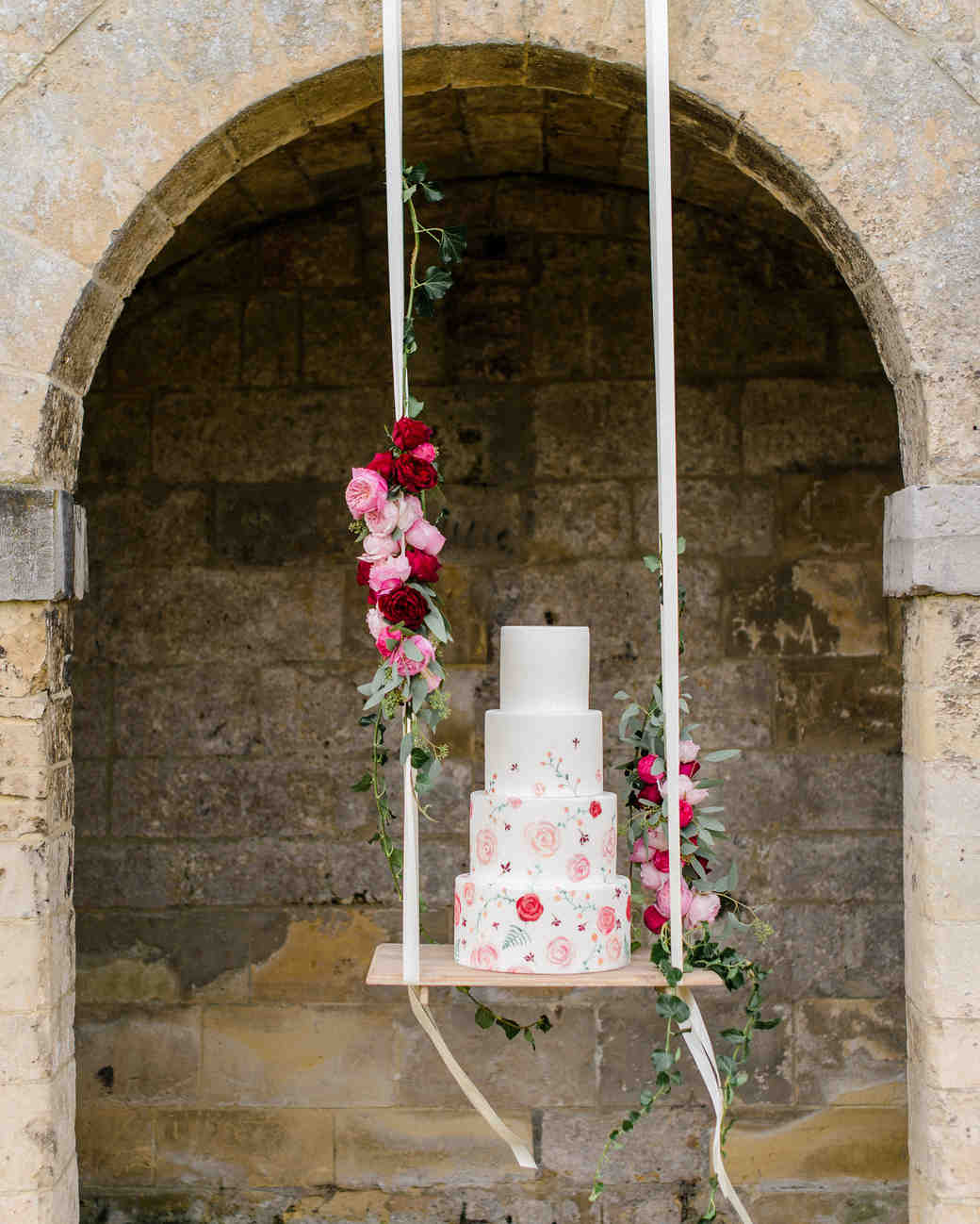 Romantic wedding cake on a hanging swing embellished with blush, deep red roses and greeneries. // Jaw-dropping suspended cake display ideas for your wedding day. // mysweetengagement.com