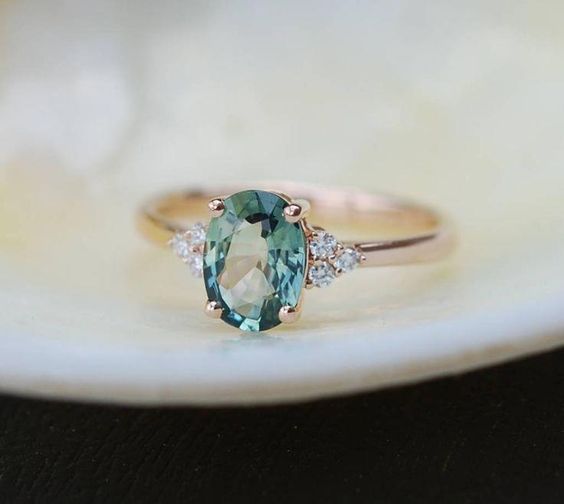 Stunning green sapphire oval engagement ring with side stones and gold band. // mysweetengagement.com