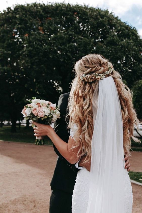 Big voluminous curls with floral piece and bridal veil on a half up half down do. // Gorgeous half up half down bridal hairstyle ideas to impress on your wedding day. // mysweetengagement.com