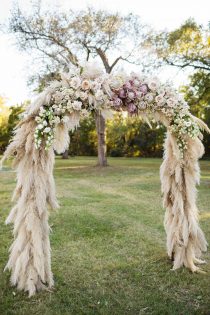 Wedding ceremony arch with pampas grass, roses and king proteus flowers.