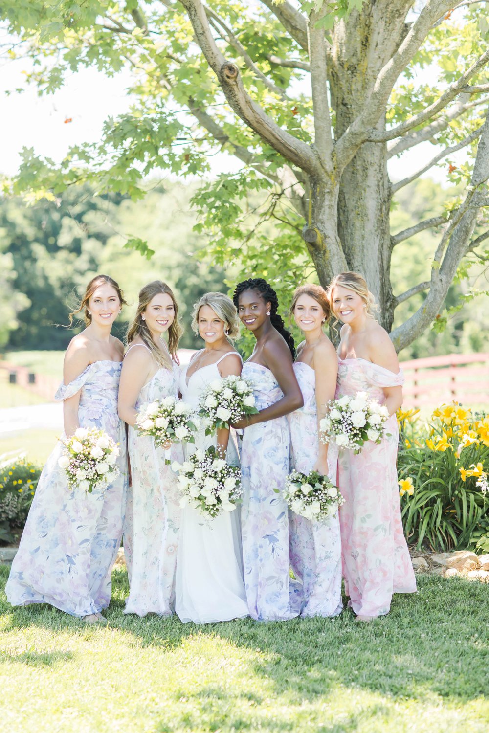 Long off the shoulder floral bridesmaid dresses in light blue and blush colors paired with white flowers bouquets