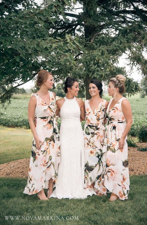 bride and bridesmaid portrait. Bridesmaids wear a V neck white floral dress with ruffled skirt
