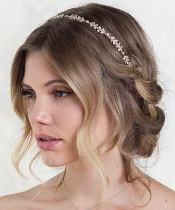 short low bridal updo with loose waves and tiara headpiece on blonde hair
