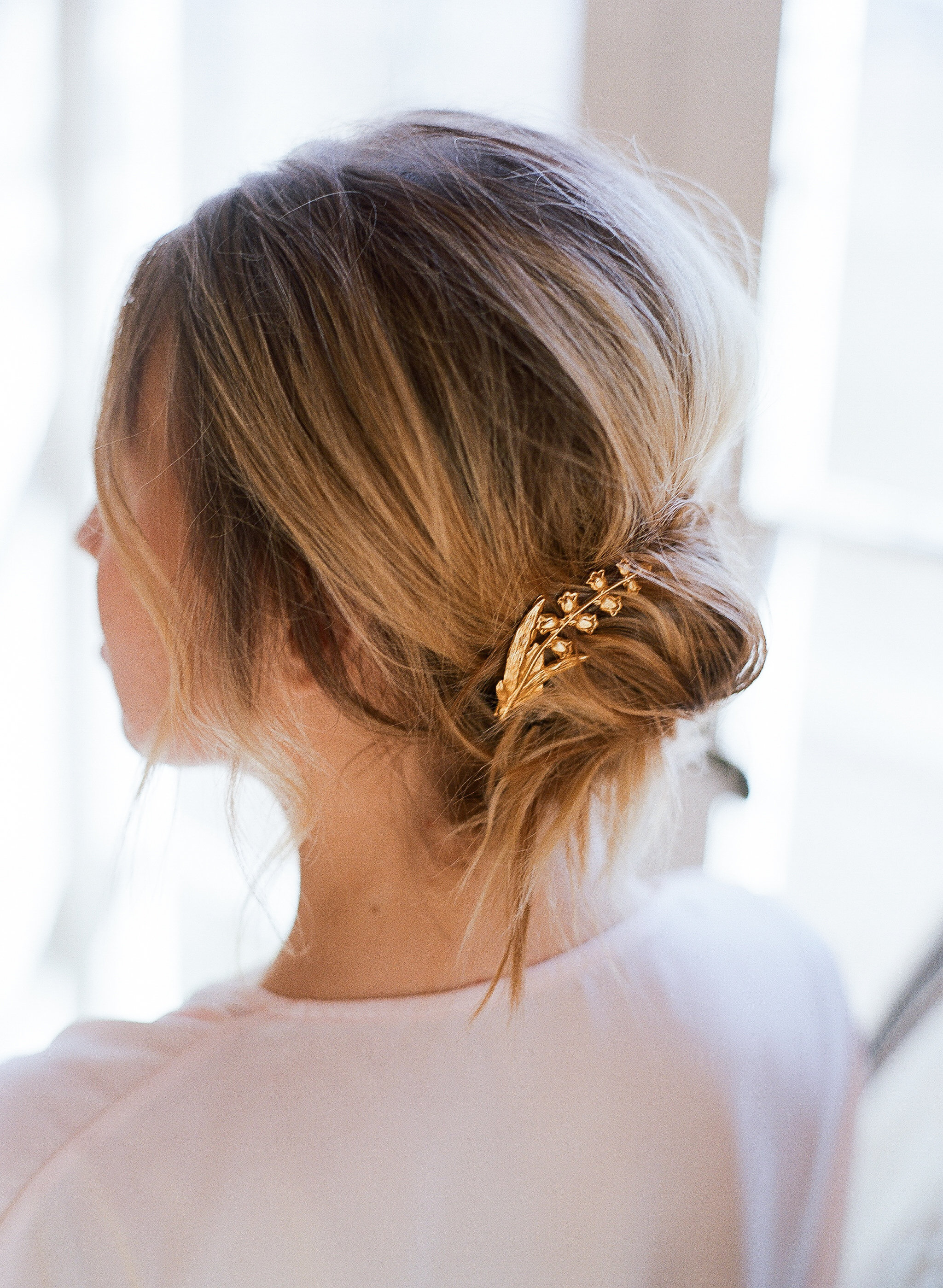 simple low hair bun hairstyle for fine straight short hair: puff crown and small bun with delicate gold accessory