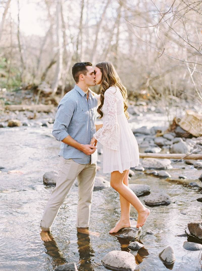 couple kissing in a creek engagement photoshoot