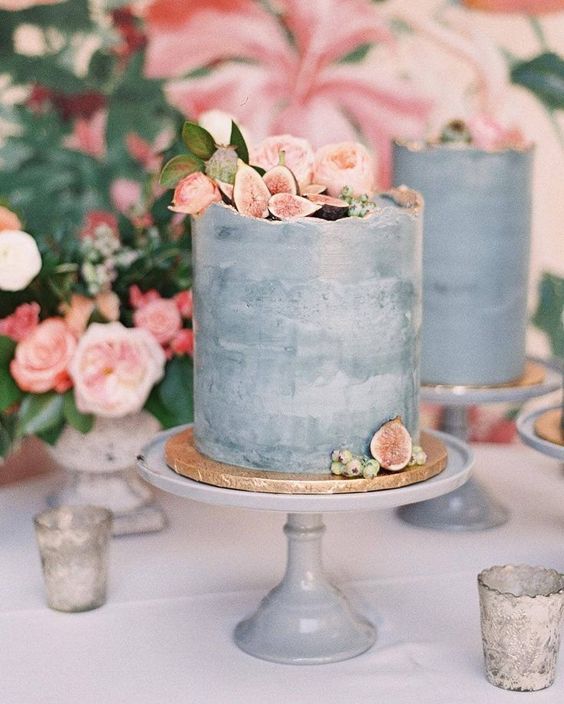one tiered gray concrete wedding cake topped with blush peonies and figs on a gold and white base
