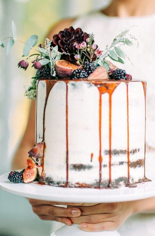 one tier white frosting caramel dripping wedding cake topped with blackberries and figs, embellished with greeneries and dark flowers