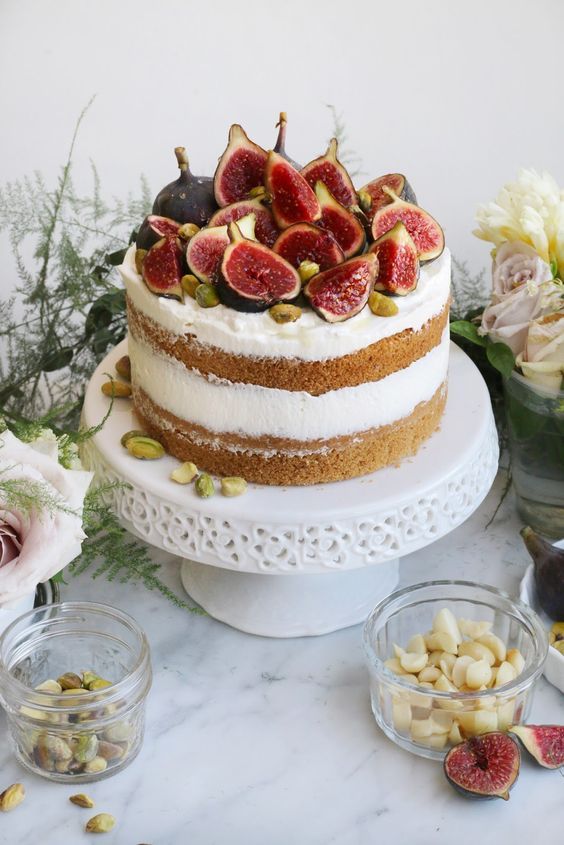 white cake with white icing topped with figs