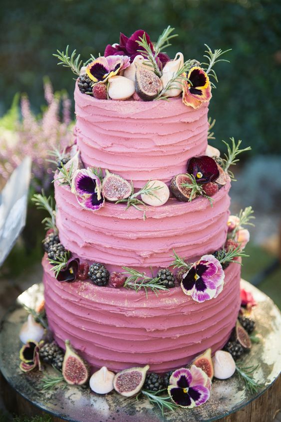 3 tiered pink ruffle wedding cake with flowers and fruits