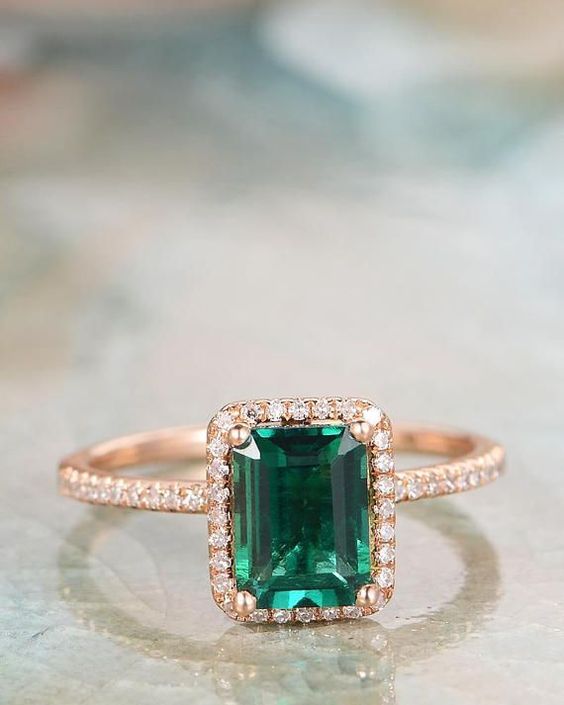 emerald gemstone engagement ring on emerald cut and gold pave diamond setting