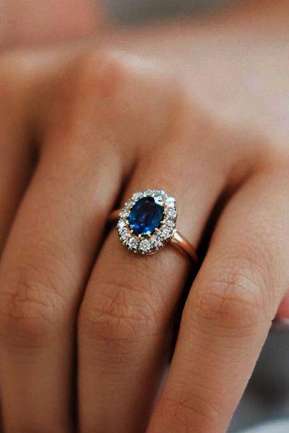 oval sapphire engagement ring with gold setting surrounded by white diamonds