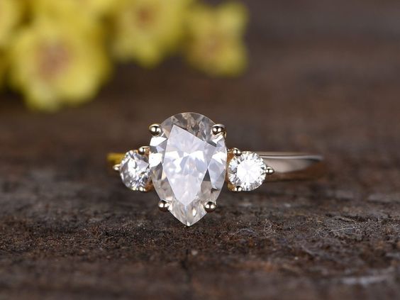3 stones diamond ring with 2 round side stones and a pear shaped center stone
