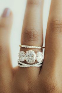 3 stone oval shaped engagement ring stacked with two wedding rings