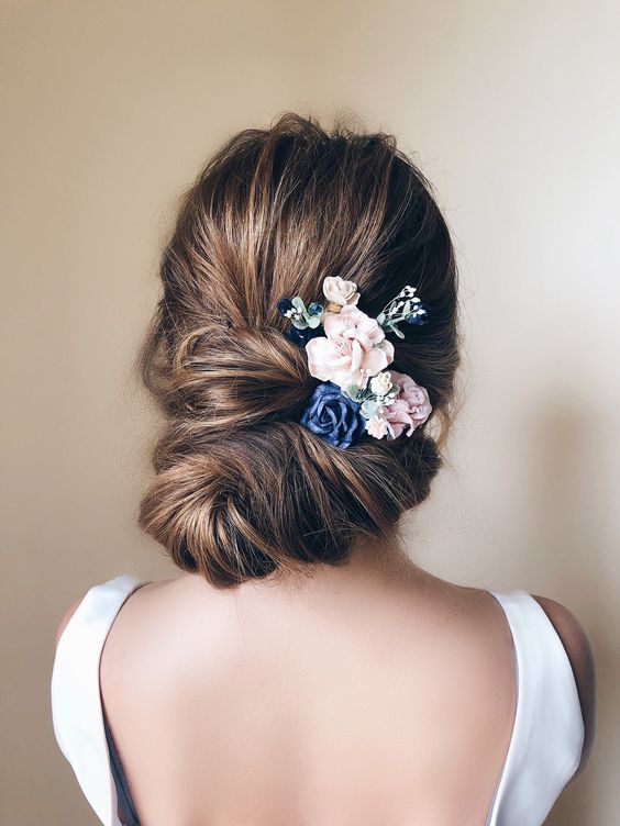 bridal wedding hair bun topped with small blush and blue flowers