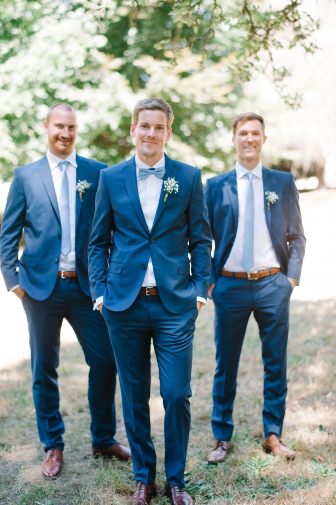 groom and groomsmen wearing Pantone Classic Blue suits and dusty blue ties and bow ties