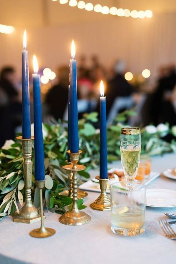 gold candleholders with navy blue colored candles