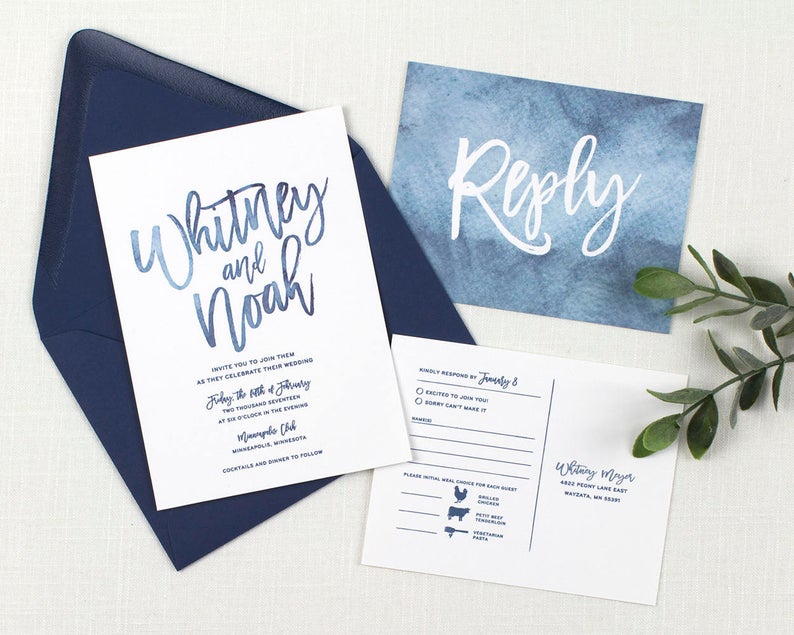 wedding invitation on white paper with Pantone classic blue hand written calligraphy and watercolor details