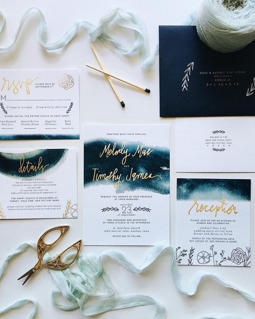 wedding stationery set on white paper, with classic blue watercolor details and gold hand written calligraphy