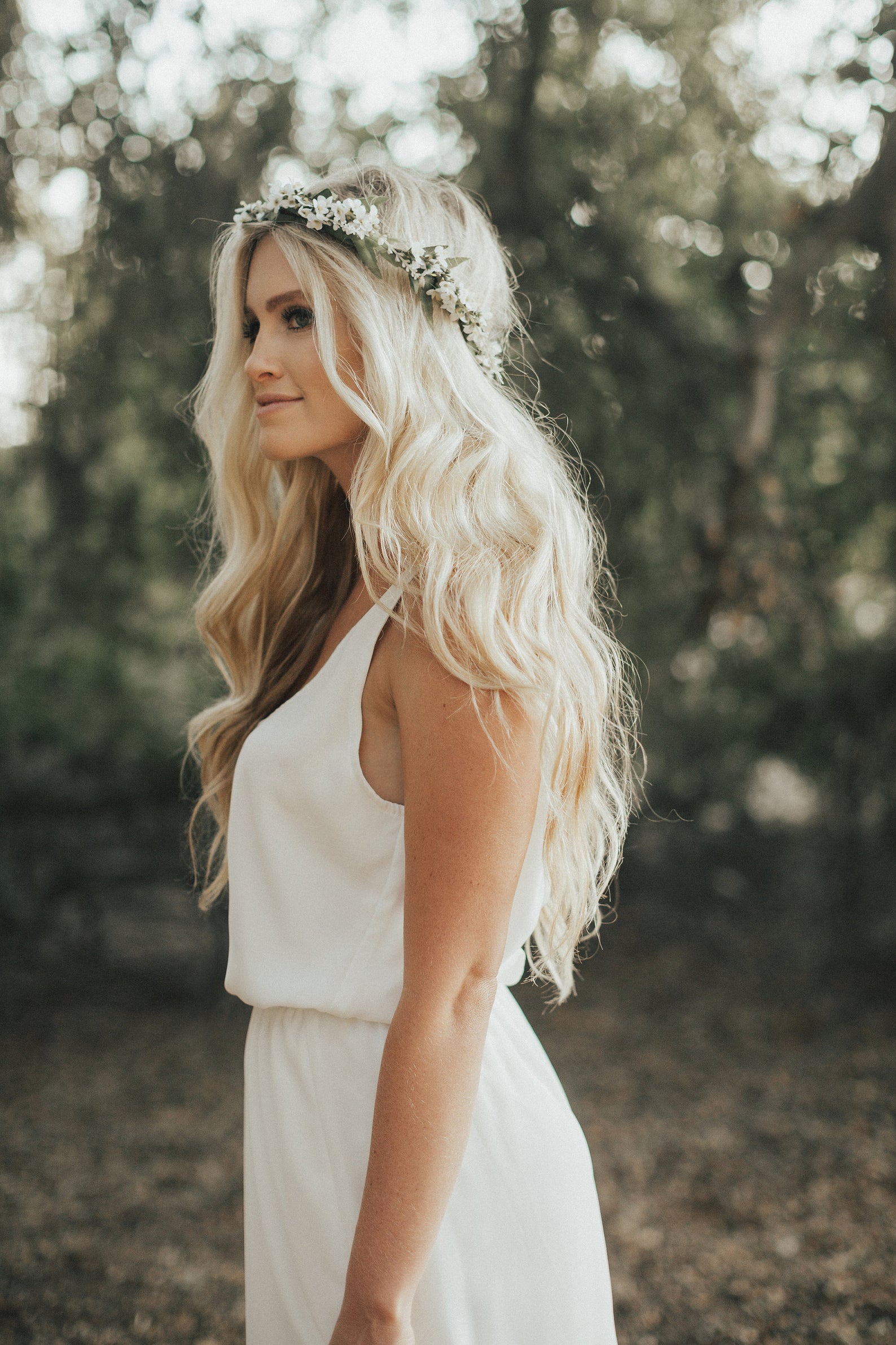 boho bride with long blonde hair wearing it down on waves, adorned with a delicate floral crown
