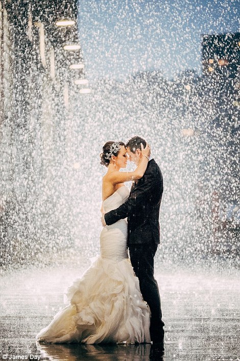 bride and groom posing hugging head to head on a rainy night