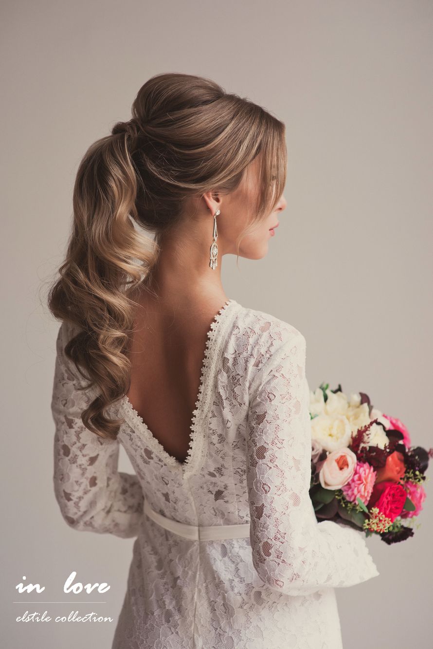 bridal hairstyle idea on blonde hair with ponytail and soft waves, with loose hair strands around the face and pouffy crown.