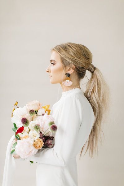 modern bride with a low messy ponytail
