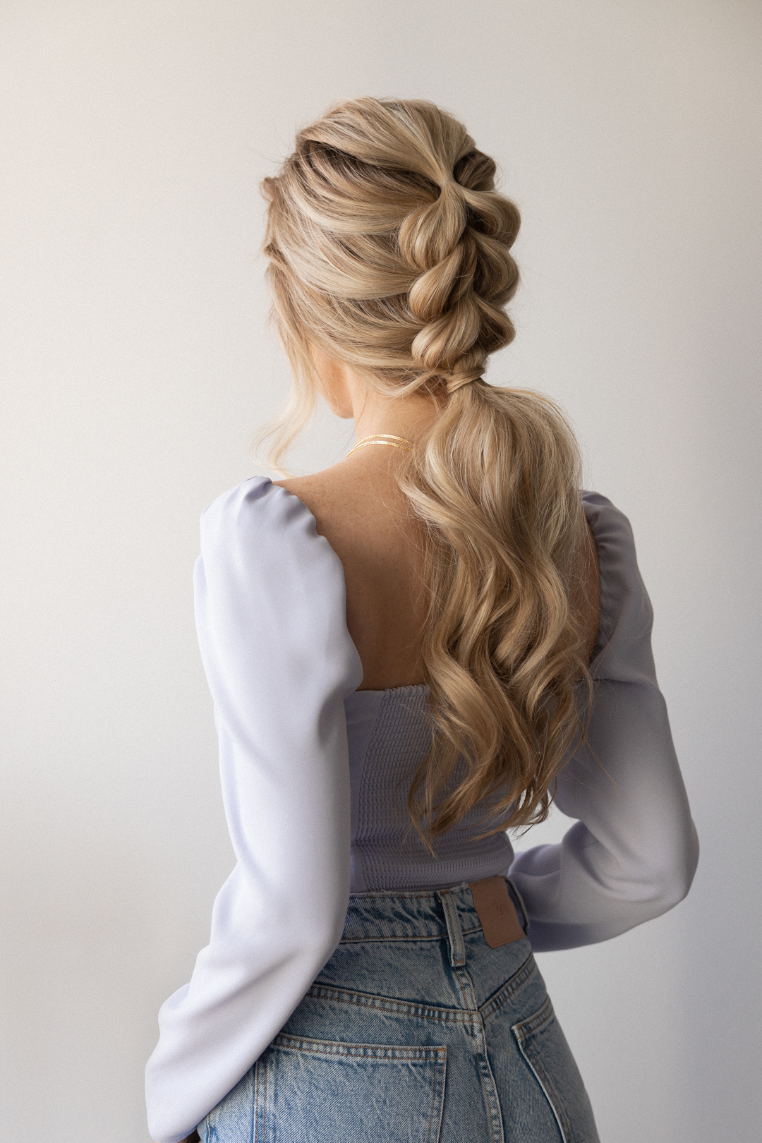 beautiful bridal hairstyle idea on blonde hair. braided on top and low ponytail, with soft waves and loose strands around the face