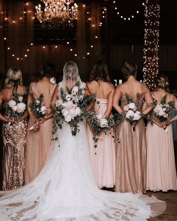 bride and bridesmaids side by side holding their wedding bouquet on their back